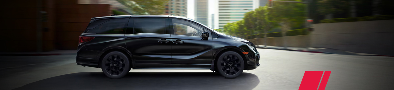 Black Honda Odyssey viewed from the side in the city